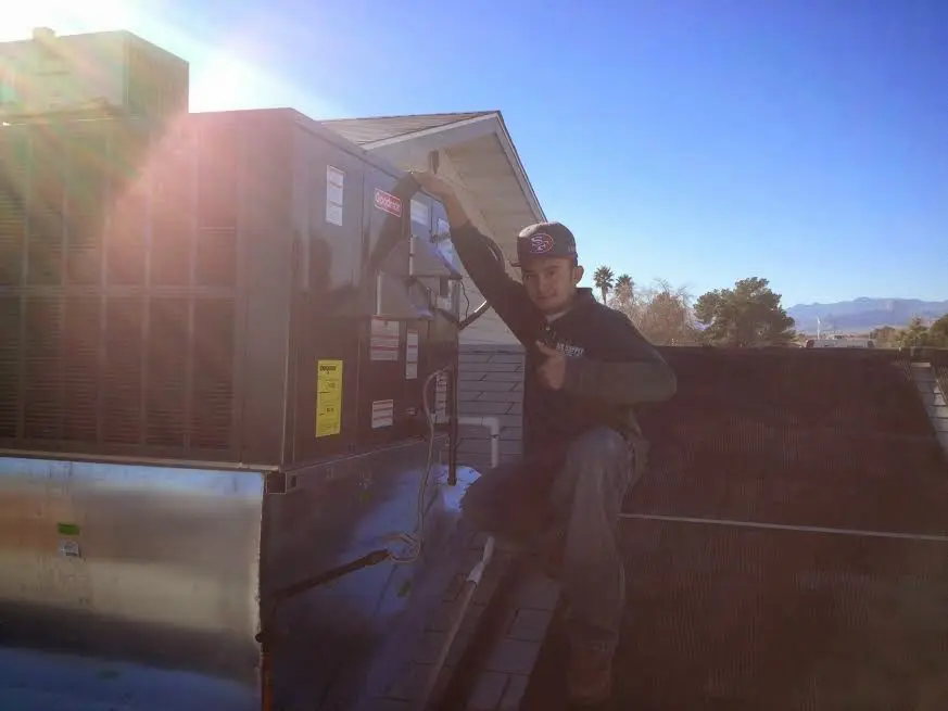 HVAC technician performing AC Tune-Up on a rooftop unit in Tucson